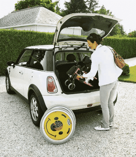 A paediatric wheelchair being placed in the boot of a car