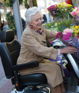 An elderly lady on a mid sized mobility scooter