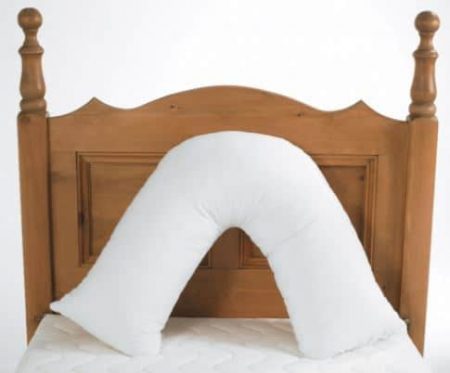 a V-Shaped orthopaedic pillow on a bed