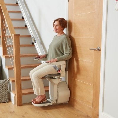 A woman sitting on an Ergo Straight stairlift