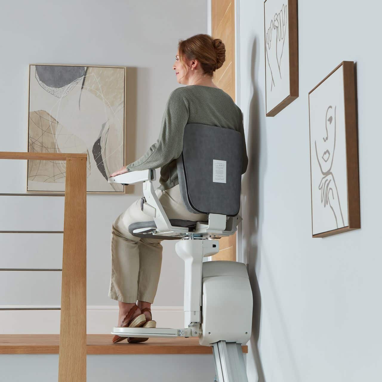 woman at top of stairs on the ergo straight stairlift